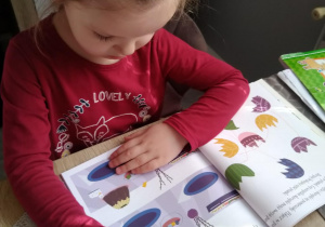 Dziewczynka wykonuje zadania w książce